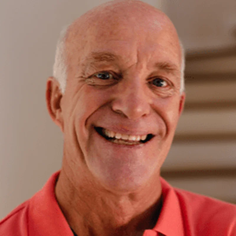 Smiling older man in a coral shirt
